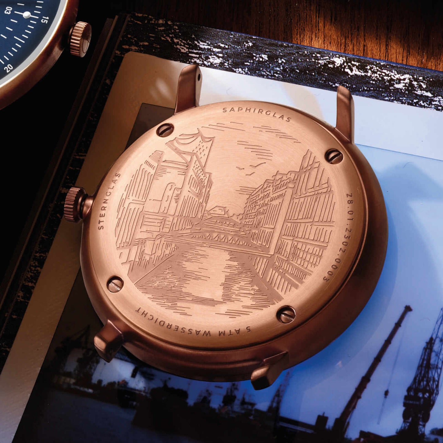 popup|Engraving "Speicherstadt" on the back|A real eye-catcher can be found on the 4-fold screwed back: The engraving of the Speicherstadt with the imposing bridges and the famous Elbphilharmonie in the background captures the spirit of the past and creates a link between tradition and modernity.