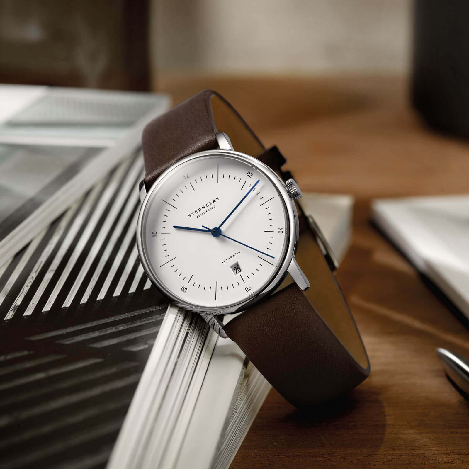 Close-up of Naos Automatik White with blue hands against white dial